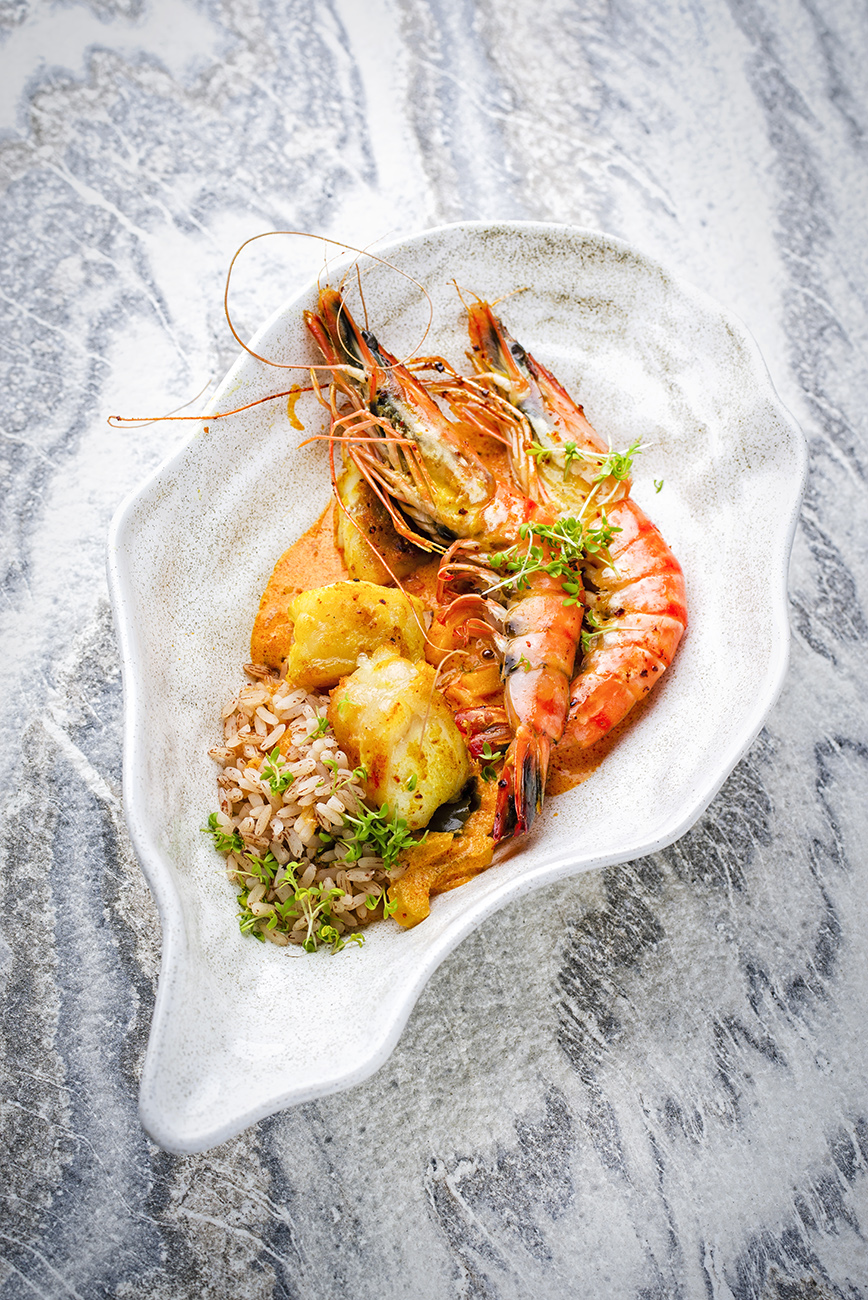 Traditional cajun stew red curry with king prawns, fish and red